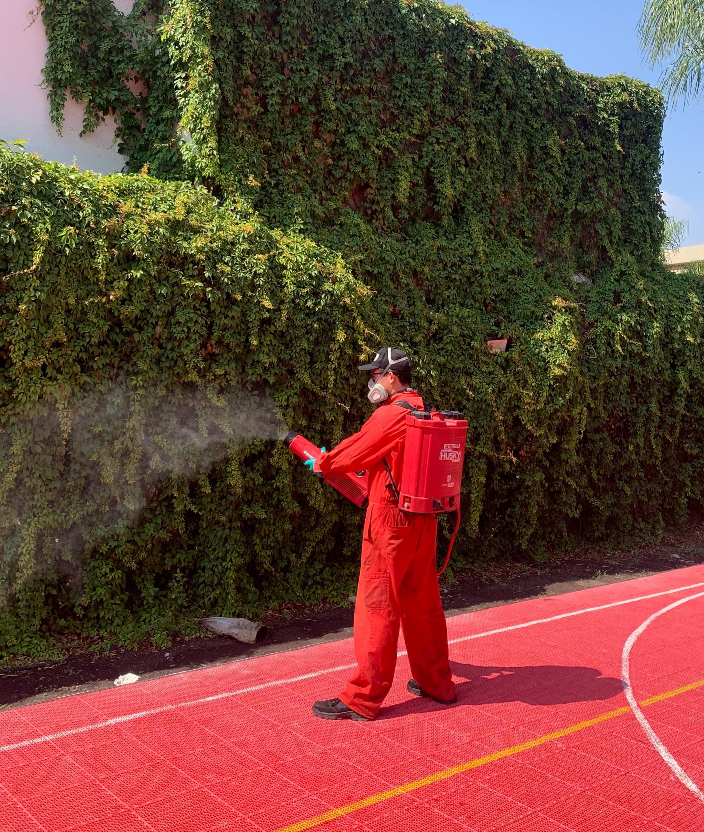 Técnico de FUR Control de Plagas fumigando área exterior